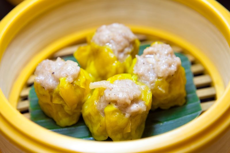 ขนมจีบหมูสี่ลูกบนใบตองในเข่งสีเหลือง