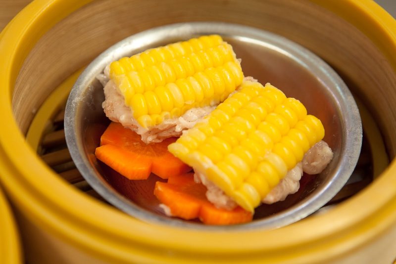 ติ่มซำข้าวโพดกับหมูสับวางบนแครอทในเข่ง
